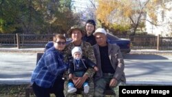 Айжигит атасы, апасы, карындашы жана иниси менен. Архивдик сүрөт