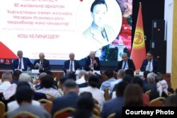 Насирдин Исановдун 80 жылдыгына арналган илимий жыйындын төрүндө отургандар. Солдон биринчи – Мамлекеттик катчы Сүйүнбек Касмамбетов. Жанында – постсоветтик Жогорку Кеңештин алгачкы төрагасы Медеткан Шеримкулов. ОшМУ, Ош шаары. Кыргызстан. 31.8.2023.