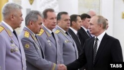 Очільник Росії Володимир Путін тисне руку тогочасному російському міністру оборони Сергію Шойгу під час нагородження керівників силових структур РФ.