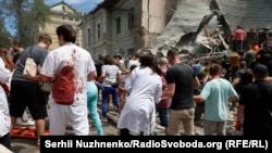 Медперсонал лікарні «Охматдит» і кияни розбирають завали на місці влучання російської ракети. Київ, 8 липня 2024 року
