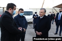 Khabibula Abdukadyr (second from left) visits a Tashkent City construction site with Uzbek President Shavkat Mirziyoev (right), as shown in a state television program.