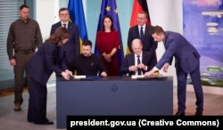 Президент України Володимир Зеленський і канцлер Німеччини Олаф Шольц (праворуч) під час церемонії підписання Угоди про співробітництво у сфері безпеки та довгострокової підтримки між Україною та Німеччиною. Берлін, 16 лютого 2024 року