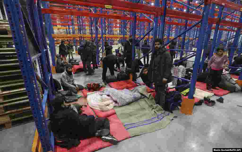 Migrants settle for the night in a logistics center at the Belarus-Poland border near Grodno, Belarus, on November 16, 2021. Human Rights Watch&nbsp;accused Belarusian authorities of manufacturing the crisis &quot;without regard for the human consequences.&quot;