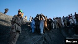 دا د کوټې د سکرو د يو کان پخوانی انځور دی چې کان کیندونکو په ګېس د وژل شوي تن مړی لېږدوي