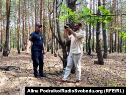 Журналист-расследователь Радио Свобода Дмитрий Джулай в лесу на окраине Бучи у ямы, в которой после российской оккупации обнаружили тела трех гражданских мужчин, август 2023 года. Информация об этом стала частью документального фильма «Буча: кто убивал и пытал? Новые лица»