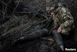 A Ukrainian soldier of the 55th Separate Artillery Brigade prepares 155 mm shells at a position near the frontline town of Maryinka in the Donetsk region in December.