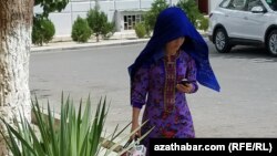 Mobil telefonyna seredip barýan zenan (Illýustrasiýa suraty)