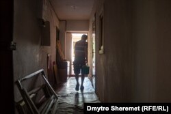 Жителі Миколаєва після нічного обстрілу 13 серпня виносять розбите скло