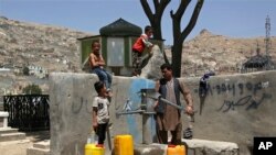 Мужчина и его дети набирают воду из общественной колонки в Кабуле, Афганистан. 30 июля 2018 г. (AP Photo/Rahmat Gul)