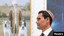 Түркмөнстандын президенти Сердар Бердымухамедов атасынын сүрөтүнүн фонунда.