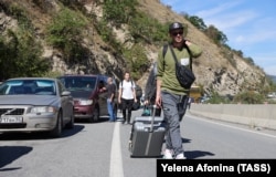 Люди та автомобілі у черзі на контрольно-пропускний пункт «Верхній Ларс» на російсько-грузинському кордоні