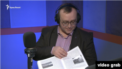 Історик Андрій Іванець демонструє монографію у студії Радіо Крим.Реалії