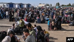 په اسلام کلا بندر کې له ایرانه ایستل شوي ګڼ افغانان د نوملیکنې لپاره انتظار باسي - د جون ۲۸مې انځور.