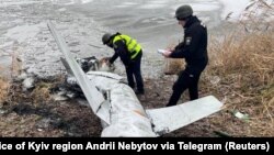 Украинские полицейские осматривают сбитую российскую крылатую ракету. Киевская область, январь 2023 года