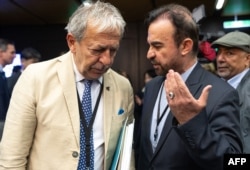 Iran's ambassador to the IAEA Reza Najafi (right) and Massimo Aparo, IAEA head of the department of safeguards, speak upon arrival for the IAEA's Board of Governors meeting in Vienna on June 9.
