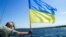 UKRAINE – Ukrainian Cossack on the Dnipro with the Flag of Ukraine 