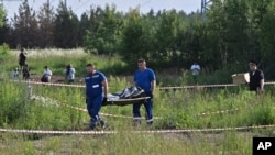 Құқық қорғау органдары қызметкерлері отставкаға кеткеніне бірнеше сағат болғаннан соң қаза болғаны хабарланған бұрынғы көлік министрі Роман Старовойттың денесін алып барады. Одинцово, Мәскеу облысы. 7 шілде, 2025 жыл. 