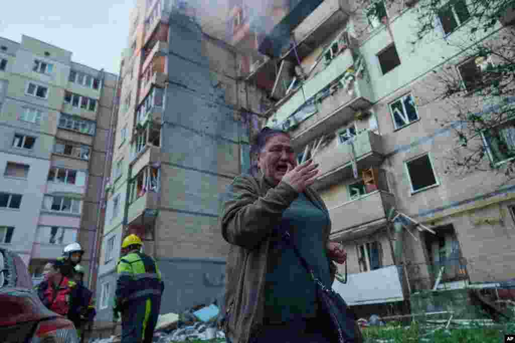 Жінка плаче, споглядаючи місце російського удару у Святошинському районі Києва