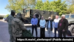 Представители сакского санатория «Северное сияние» и крымские активисты российского «Народного фронта» передают маскировочные сети российским военным во время полномасштабного вторжения РФ в Украину, май 2025 года