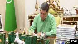 Гурбангулы Бердымухамедов за написанием книг. (Кадр из репортажа гостелевидения)