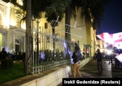 Протестующий пытается прорваться на территорию президентского дворца в Тбилиси, Грузия, 4 октября 2025 года