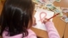 ВИЧ-инфицированная девочка в Шымкенте рисует красную ленту, символ борьбы со СПИДом 