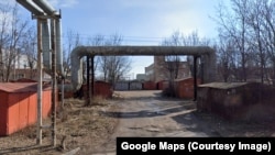 Место "прописки" "М-Логистики" – промышленное здание в Таганроге за гаражами и трубопроводом