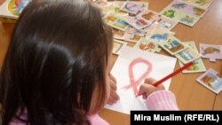 ВИЧ-инфицированная девочка рисует красную ленту, символ борьбы со СПИДом, в шымкентском Центре матери и ребёнка. 30 ноября 2020 года. О массовом заражении детей ВИЧ в городе стало известно в 2006 году