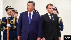 Chinese leader Xi Jinping stands next to French President Emmanuel Macron during a welcome ceremony in Beijing on December 4.