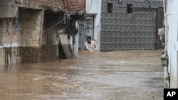 په سوات کې یو کس تر باران وروسته په کوڅه کې له سېلابي اوبو تېرېږي - د اګست ۱۵مې انځور.