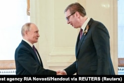 Russian President Vladimir Putin shakes hands with Serbian President Aleksandar Vucic amid events in Moscow on May 8 marking 80 years since the defeat of Nazi Germany in World War II.
