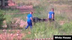 Сотрудники силовых структур уносят тело Романа Старовойта с места его предполагаемого самоубийства, 7 июля 2025 года