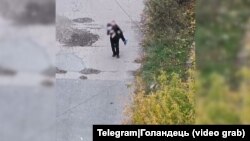 Цивільний чоловік виносить поранену російськими військовими в Покровську жінку, жовтень 2025 року
