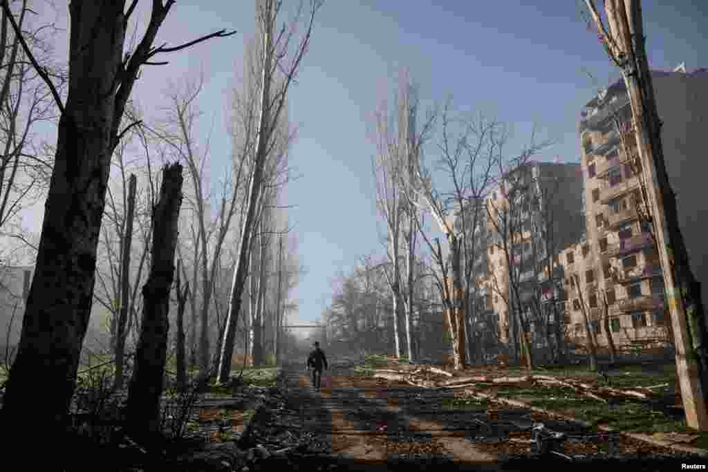 Житель идет по улице рядом с жилыми домами, поврежденными в результате российского военного удара, Константиновка в Донецкой области, Украина, 15 ноября 2025 года. Олег Петрасюк/Пресс-служба 24-й отдельной механизированной бригады им. короля Данила ВСУ