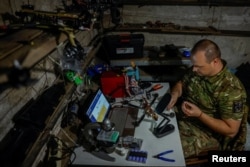 Боєць-технік 141-ї омбр Сергій у своїй майстерні для переробки російських трофейних FPV-дронів в травні 2025 року