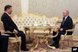 Президент России Владимир Путин и президент Китая Си Цзиньпин пьют чай во время встречи в Кремле в Москве, Россия, 8 мая 2025 года