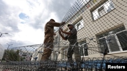 Низомиёни Русия симтӯрҳои ҳимоявиро барои пешгирии паҳподҳои укроинӣ дар давродаври як боғчаи кӯдакона дар Белгоград насб мекунанд, 25 августи соли 2025.