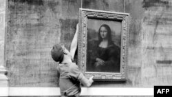 მუზეუმის თანამშრომელი 1947 წლის 6 ოქტომბერს, ლუვრის მუზეუმის დიდი გალერეის ხელახლა გახსნის დროს, ჰკიდებს მონა ლიზას ცნობილ პორტრეტს