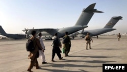 People line up to board a military aircraft as they are evacuated from Kabul. (file photo)