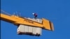 Tajik migrant on crane 