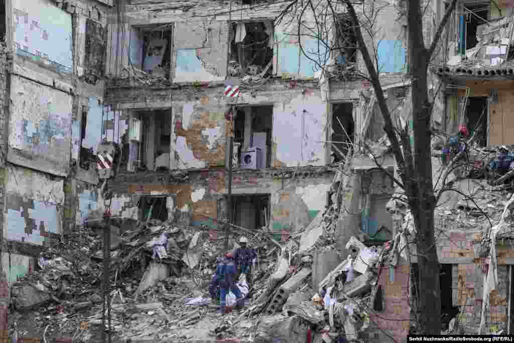 Рятувальники піднімають тіло 11-річної Марійки, яка загинула у своїй квартирі внаслідок російського ракетного обстрілу Києва. Червень 2025 року