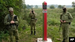 Gărzile de pază din Belarus stau la granița dintre Polonia și Belarus, în Krynki, Polonia, pe 31 august.