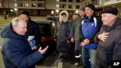 Кадр із відео, показаного російськими офіційними телеканалами: «Вдячні мешканці нових будинків у Маріуполі дякують президенту Росії Володимиру Путіну». 19 березня 2023 року