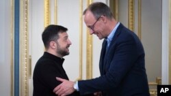 Ukrainian President Volodymyr Zelenskiy (left) and German Christian Democratic Party (CDU) Chairman Friedrich Merz shake hands during their meeting in Kyiv on December 9.