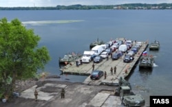 Автомобілі на понтонному поромі, який організували російські окупанти біля пошкодженого ударами ЗСУ Антонівського мосту через річку Дніпро. Окупована частина Херсонщини, 3 серпня 2022 року