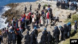 Мигранты в окружении итальянских полицейских на берегу Средиземного моря на французско-итальянской границе. Вентимилья, 30 сентября 2022 года