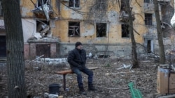 Чоловік сидить на лавці біля багатоквартирного будинку, пошкодженого внаслідок російського удару, Костянтинівка, Донецька область, 7 грудня 2025 року