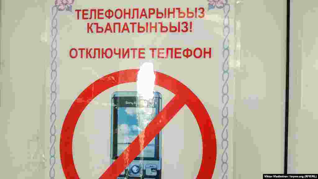 Caminiñ içinde telefonlarnı söndürmek kerek olğanı aqqında ilân bar