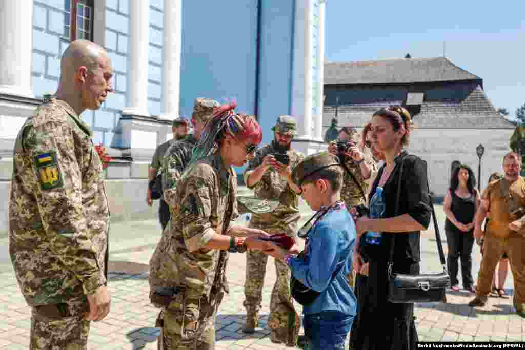 У Михайлівському Золотоверхому соборі Києва відбулося прощання із головним сержантом 68-ї окремої єгерської бригади ЗСУ Антоном Усовським. Під час прощання нагороди батька вручають його синові. Київ, серпень 2023 року