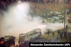 Soviet tanks, engulfed in a cloud of tear gas, roll through a barricade of cars surrounding Lithuania's main broadcast station in Vilnius in January 1991.